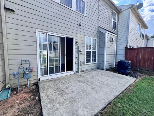 a view of a house with a backyard and a patio