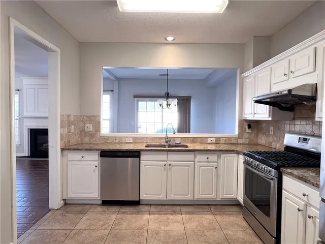 a kitchen with a sink stove top oven and cabinets