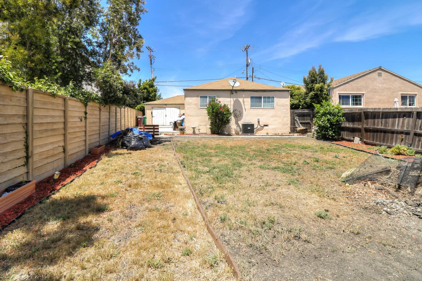 317 Tennyson Road Hayward, CA 94544 - Photo 19 of 21 a view of a house with a yard and garage