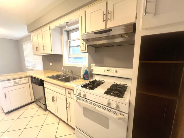 a kitchen with granite countertop white cabinets and white appliances