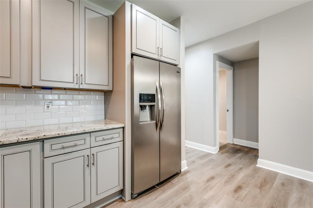 3912 Rawlins Street, Unit 2 Dallas, TX 75219 - Photo 14 of 25 a kitchen with granite countertop stainless steel appliances a refrigerator and cabinets