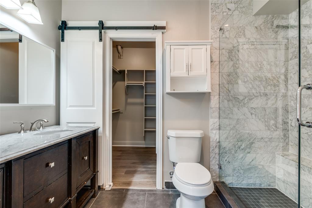 3912 Rawlins Street, Unit 2 Dallas, TX 75219 - Photo 21 of 25 a bathroom with a granite countertop sink toilet and shower
