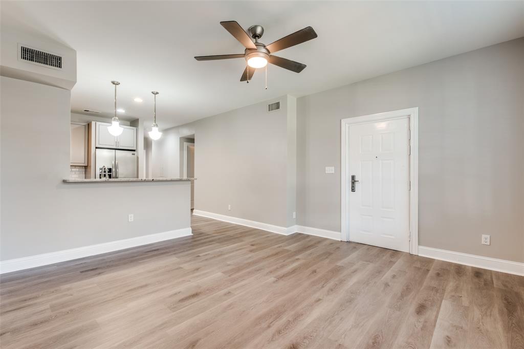 3912 Rawlins Street, Unit 2 Dallas, TX 75219 - Photo 7 of 25 an empty room with wooden floor and a ceiling fan