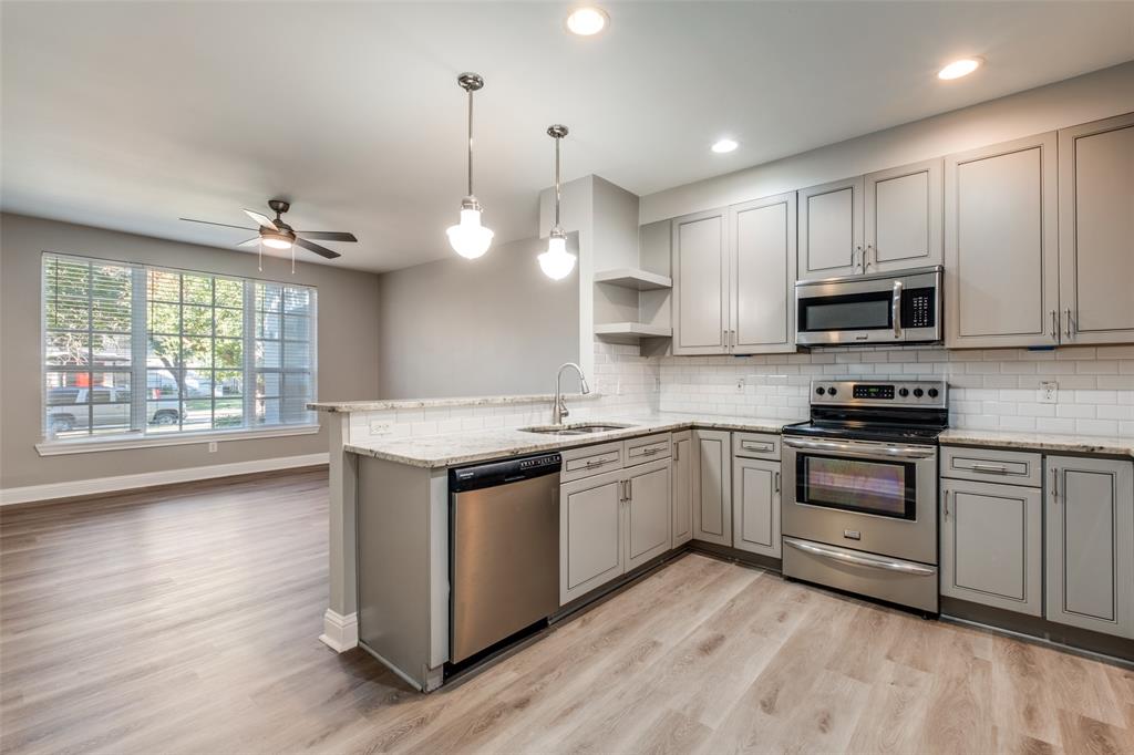 3912 Rawlins Street, Unit 2 Dallas, TX 75219 - Photo 8 of 25 a kitchen with stainless steel appliances granite countertop a stove a sink and a microwave