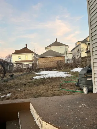 a view of a large white house with a yard