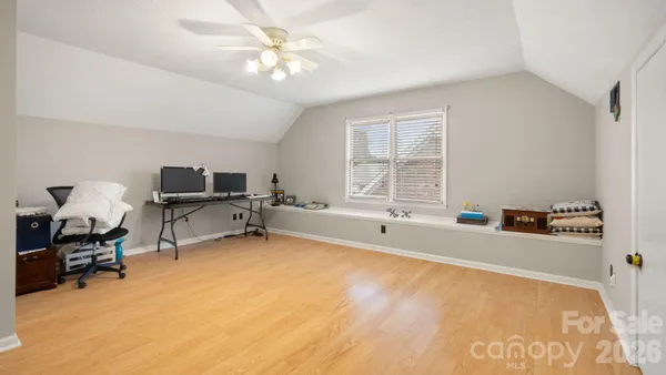 a view of a workspace with furniture and a window