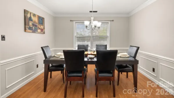 a view of a dining room with furniture a chandelier and wooden floor