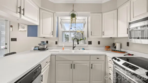 a kitchen with a sink stove top oven and cabinets