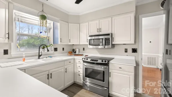 a kitchen with white cabinets sink and stainless steel appliances