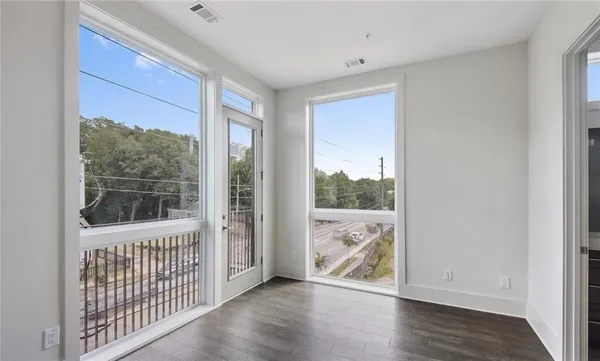 an empty room with wooden floor and windows