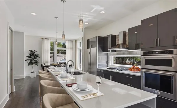 a open kitchen with stainless steel appliances kitchen island granite countertop a dining table and chairs