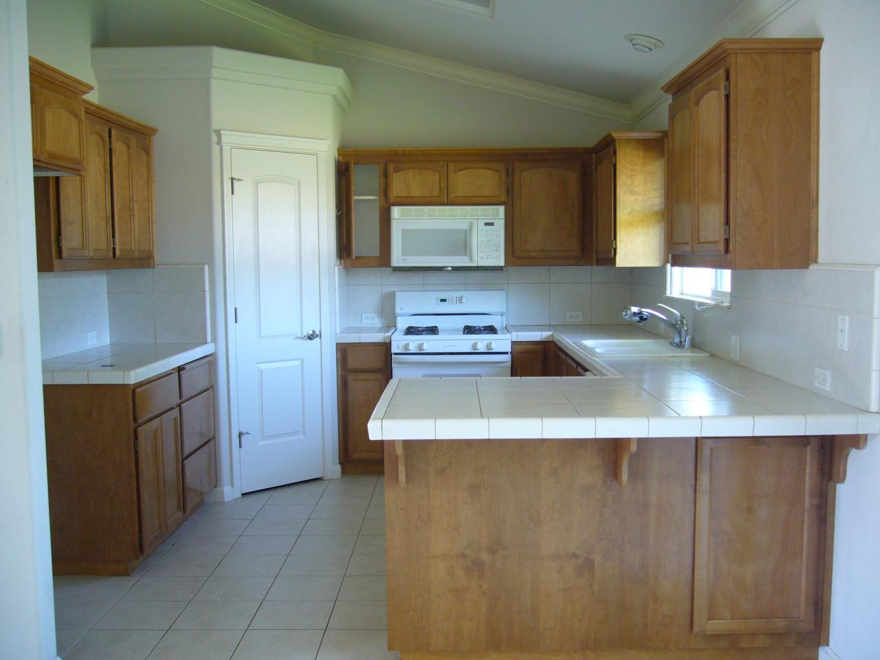 2674 Rhinestone Way Redding, CA 96001 - Photo 3 of 7 a kitchen with sink a refrigerator and cabinets