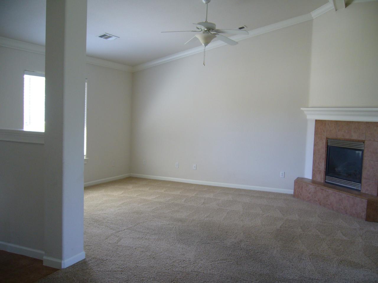 2674 Rhinestone Way Redding, CA 96001 - Photo 4 of 7 an empty room with a fireplace and fan