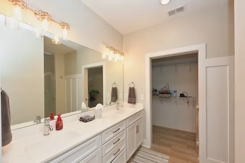 a bathroom with a double vanity sink mirror and shower