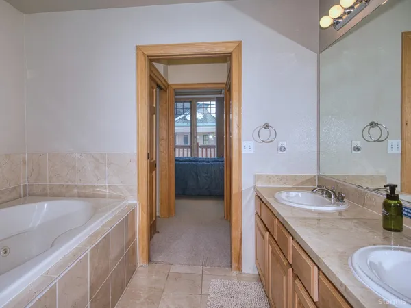 a bathroom with a tub sink and mirror