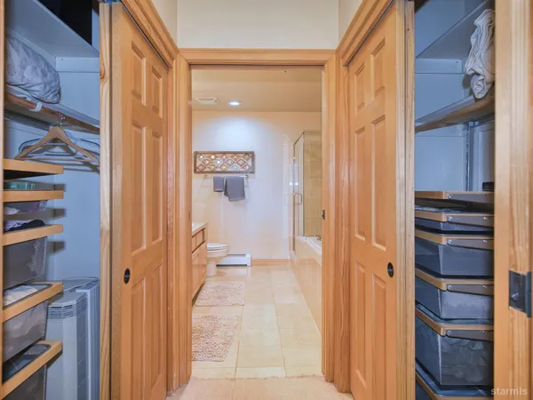 a view of a hallway with closet and wooden floor
