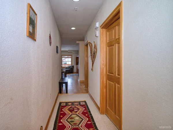 a view of hallway with stairs and wooden floor