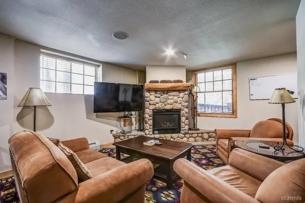 a living room with furniture a flat screen tv and a fireplace