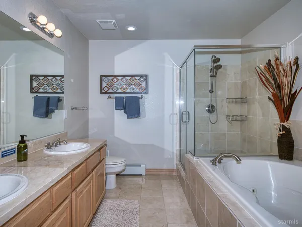a spacious bathroom with a granite countertop tub sink a mirror a shower and a bathtub