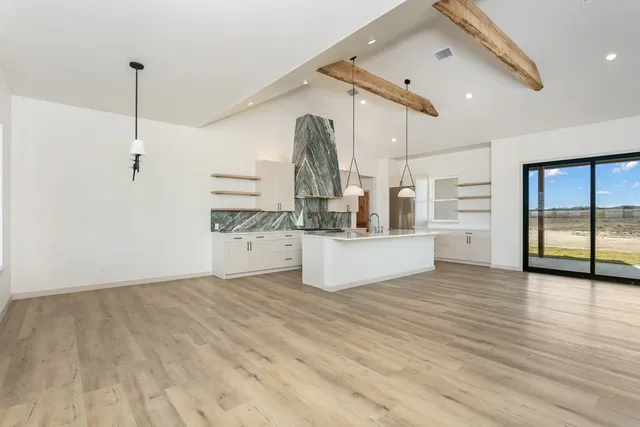 a view of an empty room with a fireplace and a window