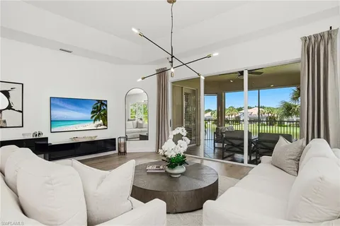 a living room with furniture a flat screen tv and a large window