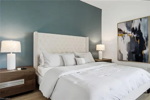 a large bed sitting in a bedroom and a lamp