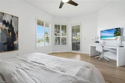 a bedroom with a bed and furniture with a flat tv screen