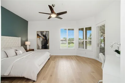 a bedroom with a bed and a large window