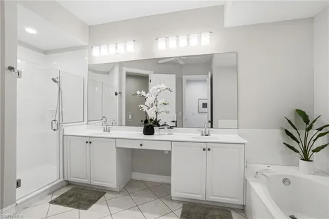 a bathroom with a sink a large mirror and a bathtub