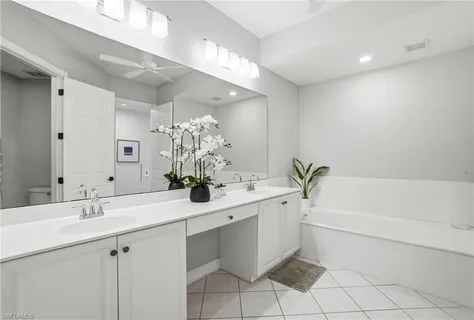 a bathroom with a bathtub sink and mirror