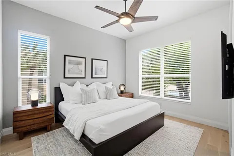a bedroom with a large bed and a chandelier fan