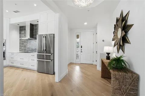 a kitchen with stainless steel appliances kitchen island granite countertop a refrigerator and a stove top oven