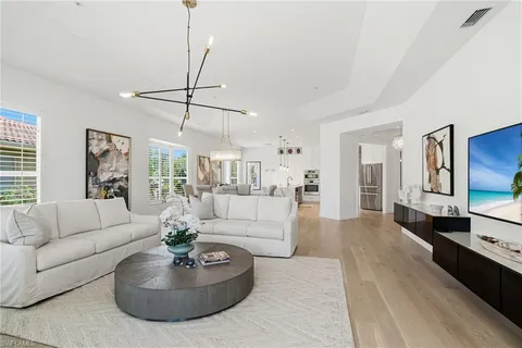 a living room with furniture a flat screen tv and a large window