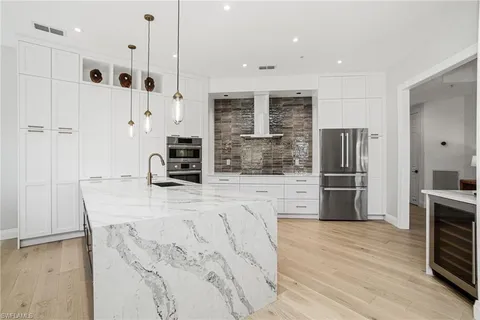 a kitchen with stainless steel appliances a refrigerator and a stove top oven