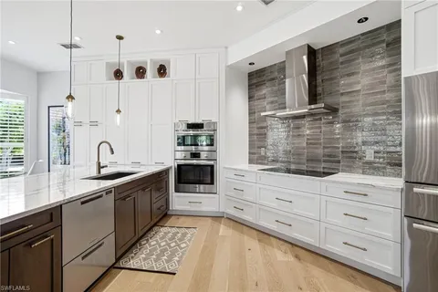 a kitchen with granite countertop a sink stainless steel appliances and cabinets