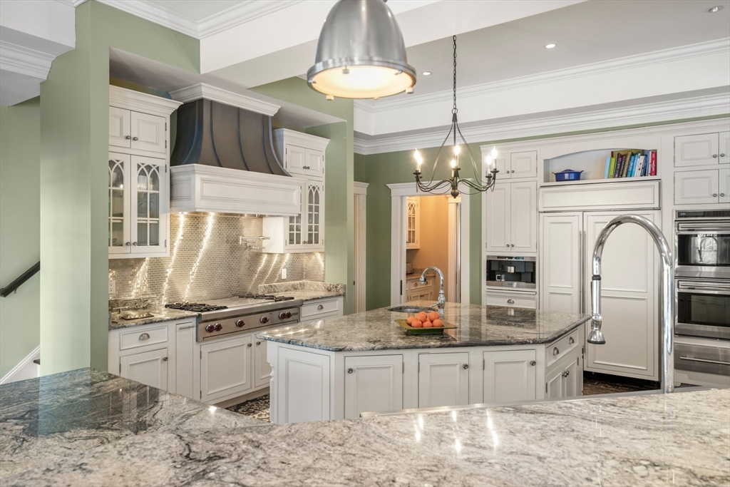 427 Hillside Street Milton, MA 02186 - Photo 12 of 42 a kitchen with stainless steel appliances kitchen island granite countertop a stove a sink and a refrigerator