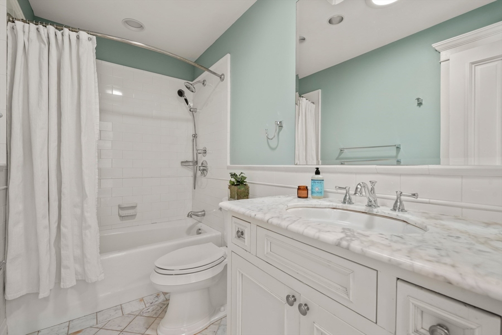 427 Hillside Street Milton, MA 02186 - Photo 32 of 42 a bathroom with a granite countertop sink a toilet and shower