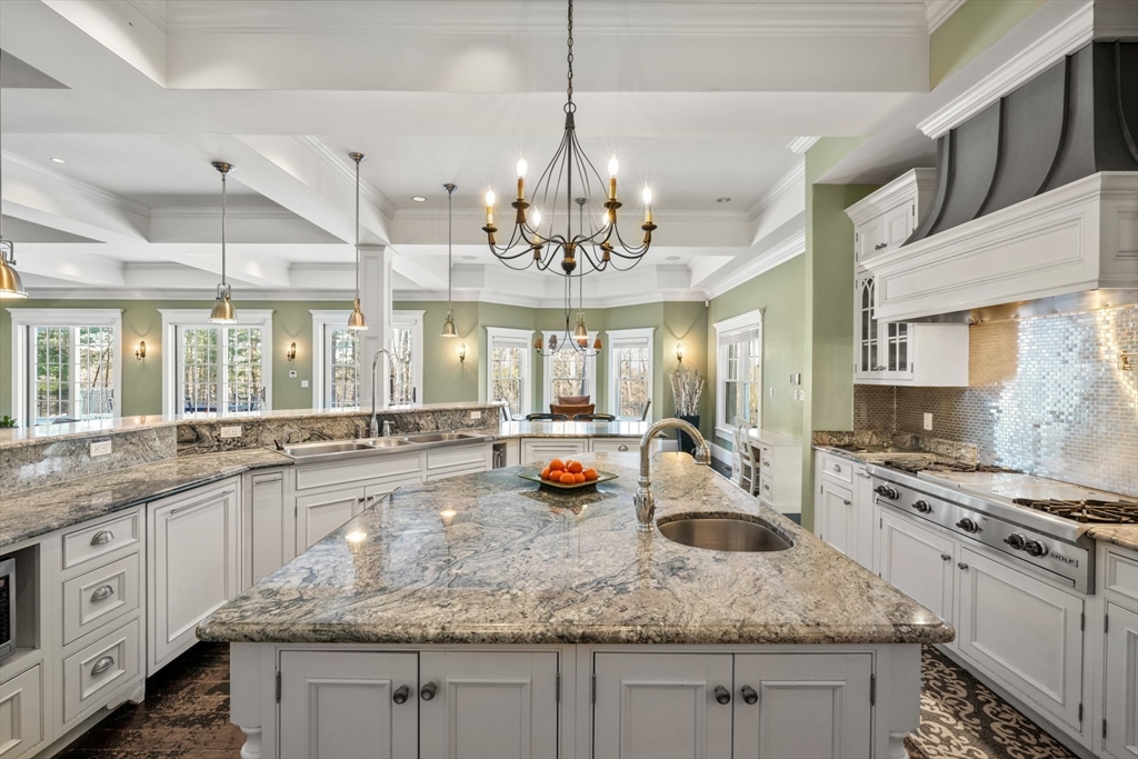 427 Hillside Street Milton, MA 02186 - Photo 10 of 42 a kitchen with kitchen island granite countertop a sink stove and cabinets