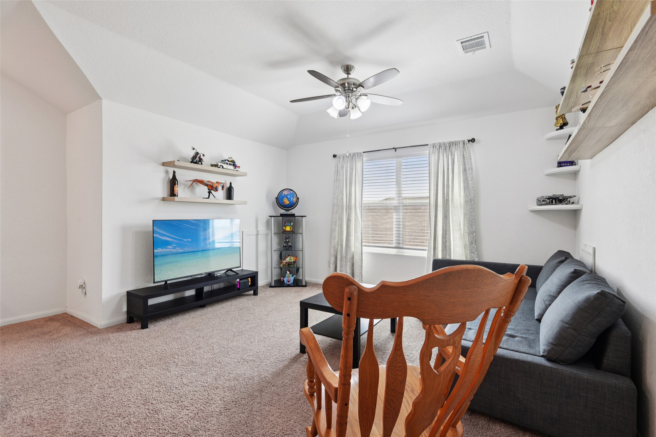 9058 Bowie Ridge Seguin, TX 78155 - Photo 22 of 40 Living area featuring a ceiling fan, light colored carpet, and vaulted ceiling