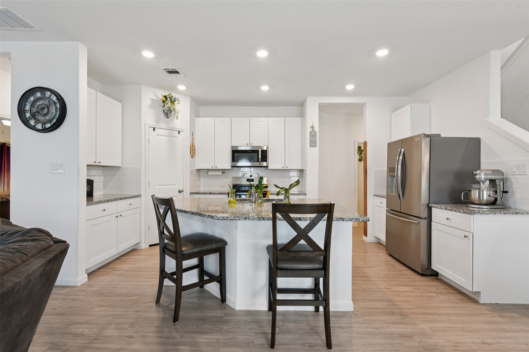 9058 Bowie Ridge Seguin, TX 78155 - Photo 10 of 40 Kitchen with dark stone counters, stainless steel appliances, decorative backsplash, light wood-type flooring, and a breakfast bar