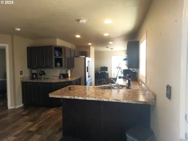 a large kitchen with kitchen island a sink stainless steel appliances and cabinets