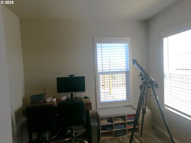 a view of a workspace with furniture and a window