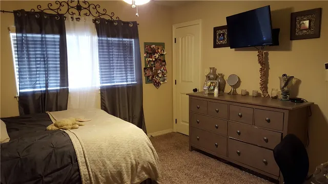 a bedroom with a bed and flat screen tv