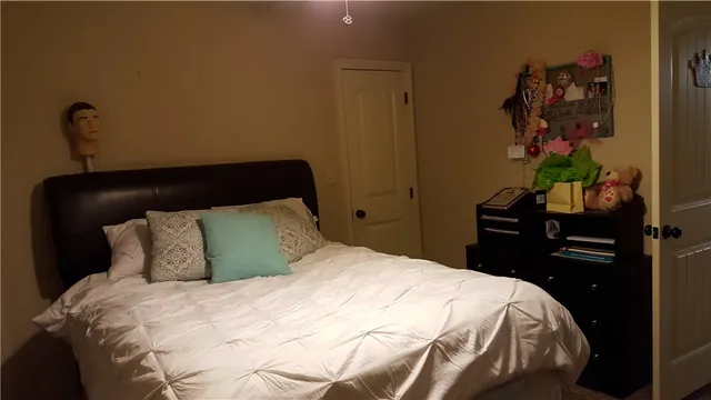 a bedroom with a bed and a potted plant