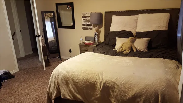 a large bed sitting in a bedroom next to a window