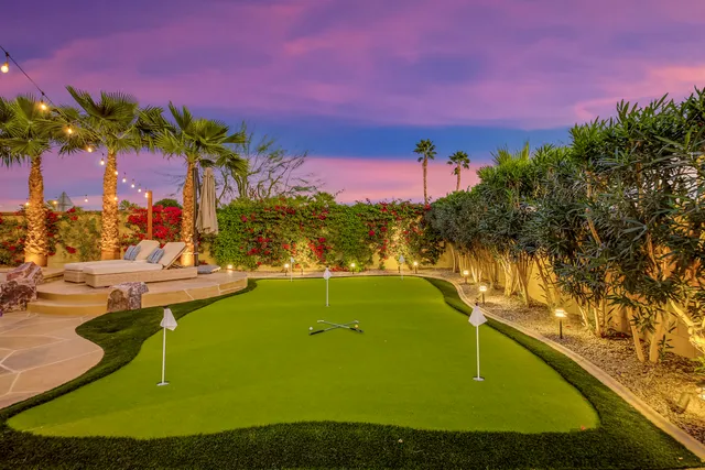 a large kitchen with kitchen island granite countertop a stove a sink a oven a dining table and chairs with wooden floor