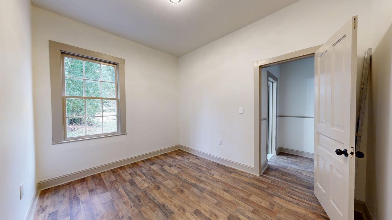860 Stokes Street Danville, VA 24541 - Photo 11 of 32 a view of an empty room with wooden floor and a window