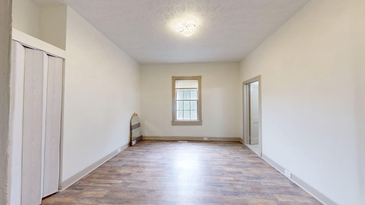 860 Stokes Street Danville, VA 24541 - Photo 12 of 32 an empty room with wooden floor and windows