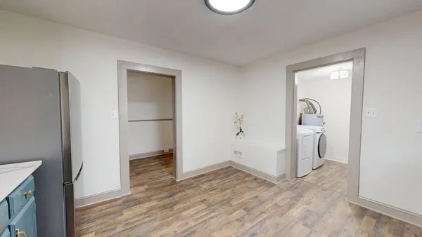 a view of empty room with wooden floor and fan