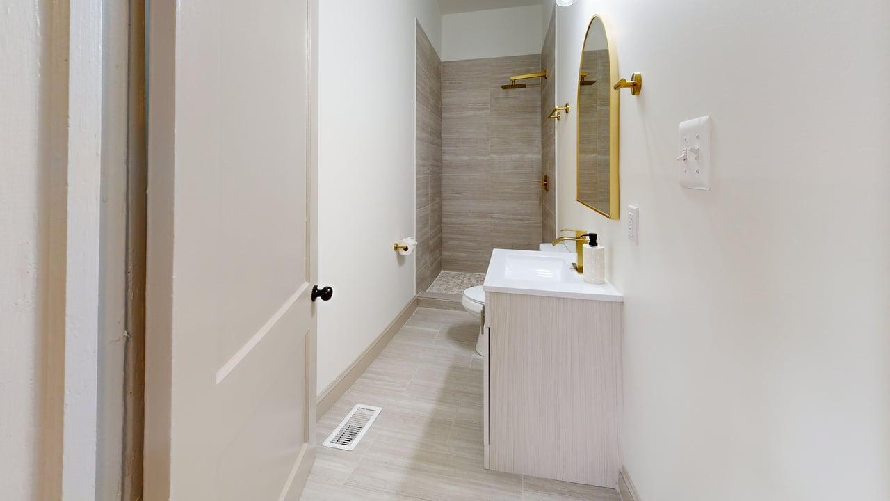 860 Stokes Street Danville, VA 24541 - Photo 21 of 32 a bathroom with a sink a mirror and a shower